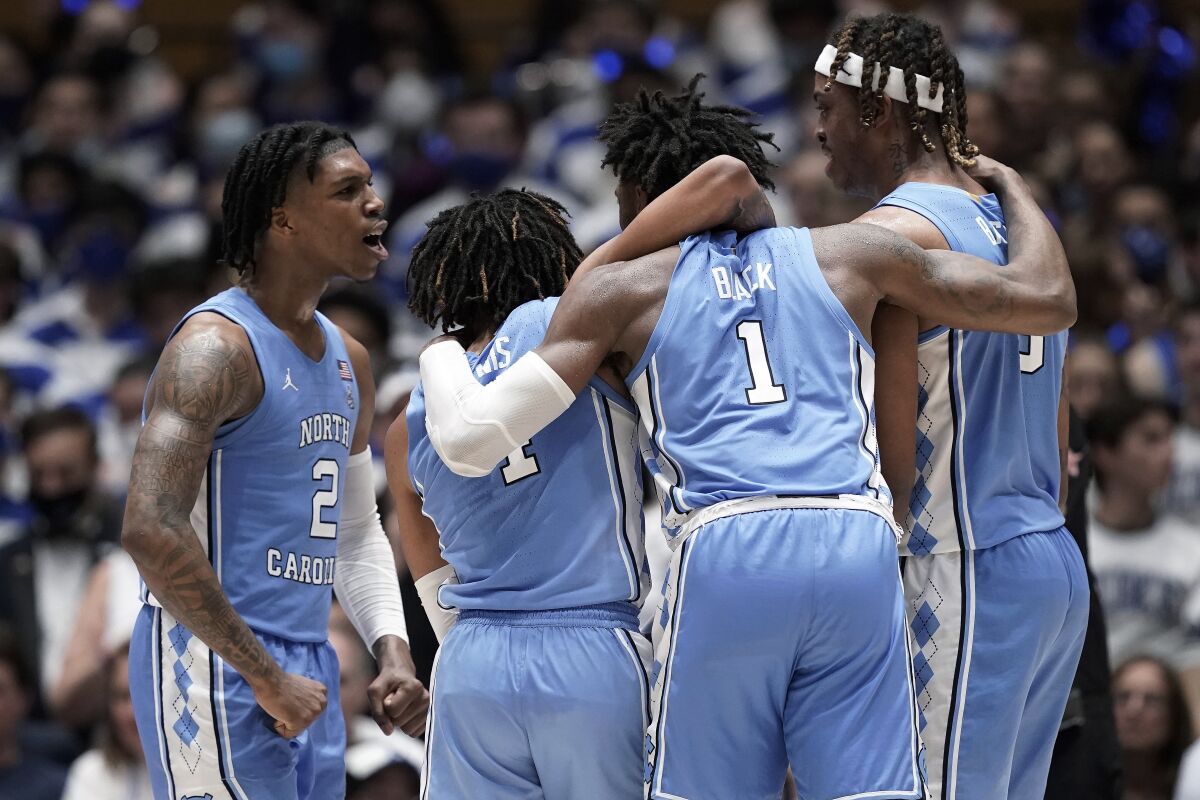 North Carolina guard Caleb Love (2) celebrates with guard R.J. Davis, guard Leaky Black (1) and forward Armando Bacot (5) late in the second half of the team's NCAA college basketball game against Duke in Durham, N.C., Saturday, March 5, 2022. (AP Photo/Gerry Broome)