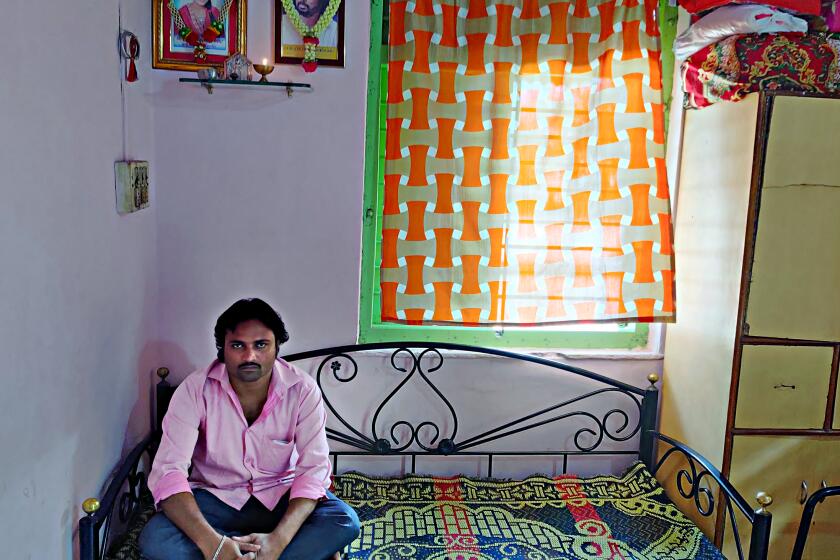 The man in pink shirt is Jaydeep Sakat, sitting in his Pune apartment under pictures of his father and daughter.