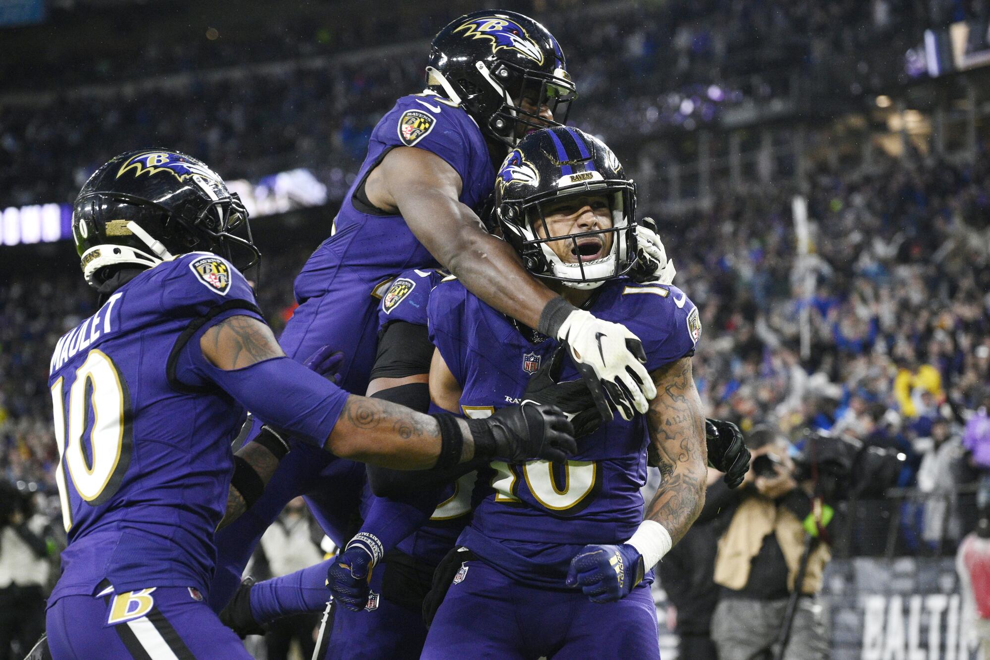 Baltimore Ravens punt returner Tylan Wallace celebrates with teammates on the field.