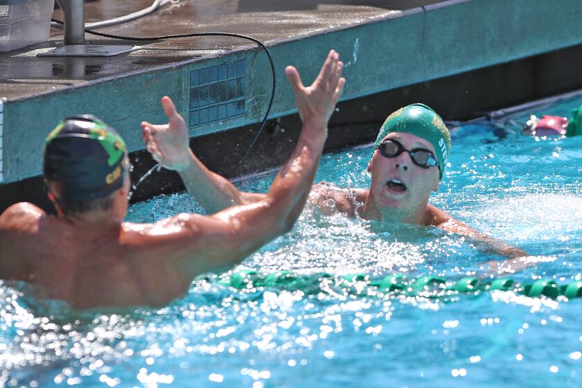 Edison's Chase Purvis and Ryder Steven, from left, finish one and two respectively after swimming the boys' varsity IM 200 during the Wave League swim finals at Golden West College on Thursday.