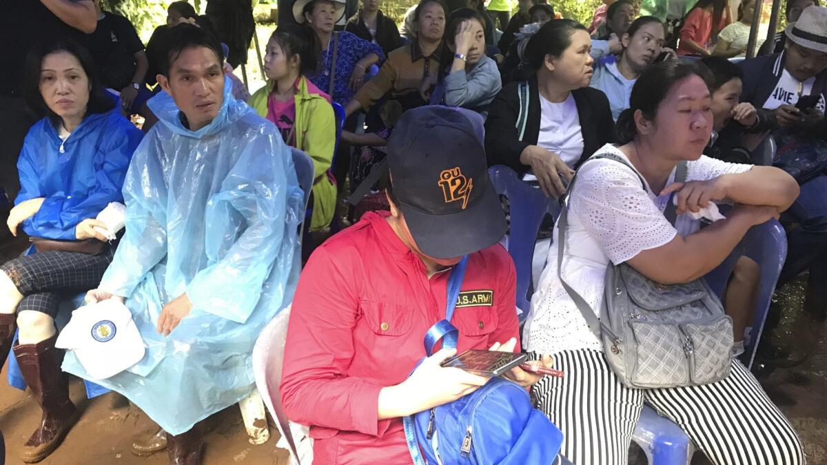 Relatives of the boys and their coach missing in a flooded cave wait under a tented area in Mae Sai, Chiang Rai province, northern Thailand.