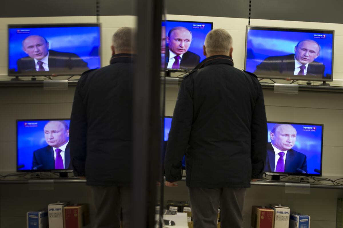 Vladimir Putin appears on multiple TV screens