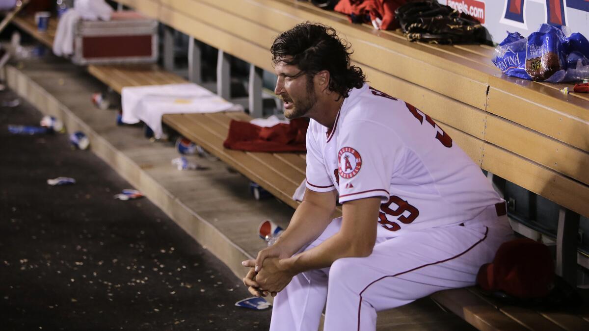 Angels reliever Jason Grilli sits in the dugout after being pulled in the fifth inning of a 13-2 loss to the Seattle Mariners on Tuesday.