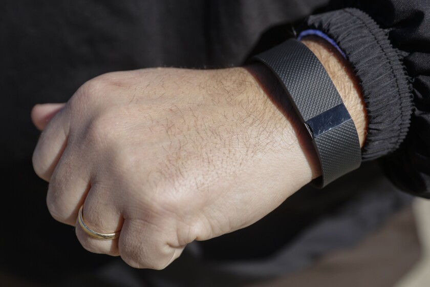 Fitbit said there are no plans to use Coin's technology in its 2016 products. Above, a man wears a Fitbit fitness tracker on his wrist.