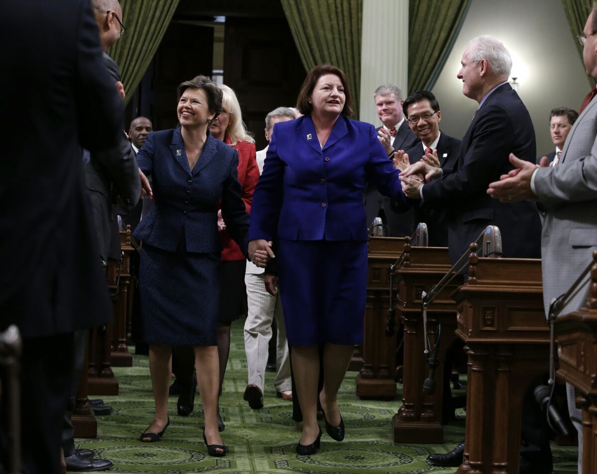 FILE - In this Monday, May 12, 2014 file photo, Assembly Speaker-elect Toni Atkins, D-San Diego, right, walks hand in hand with her spouse, Jennifer LeSar, to the rostrum of the Assembly where she took the oath of office as the 69th Assembly Speaker at the Capitol in Sacramento, Calif. Atkins told an audience of women Tuesday, June 17, 2014, there was nothing courageous about her kissing her spouse when she was sworn in last month. The San Diego Democrat says the little backlash to photos of the kiss reflects growing tolerance. (AP Photo) The Associated Press