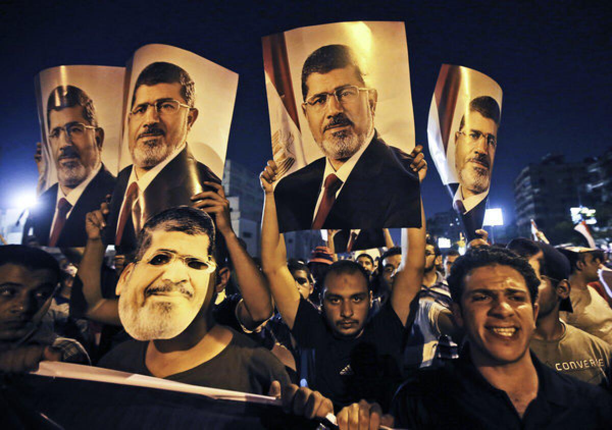 Supporters of ousted Egyptian President Mohamed Morsi hold posters of him as they protest in Cairo's Nasr City neighborhood.