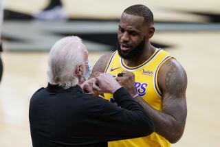 Los Angeles Lakers forward LeBron James, right, greets San Antonio Spurs coach Gregg Popovich.