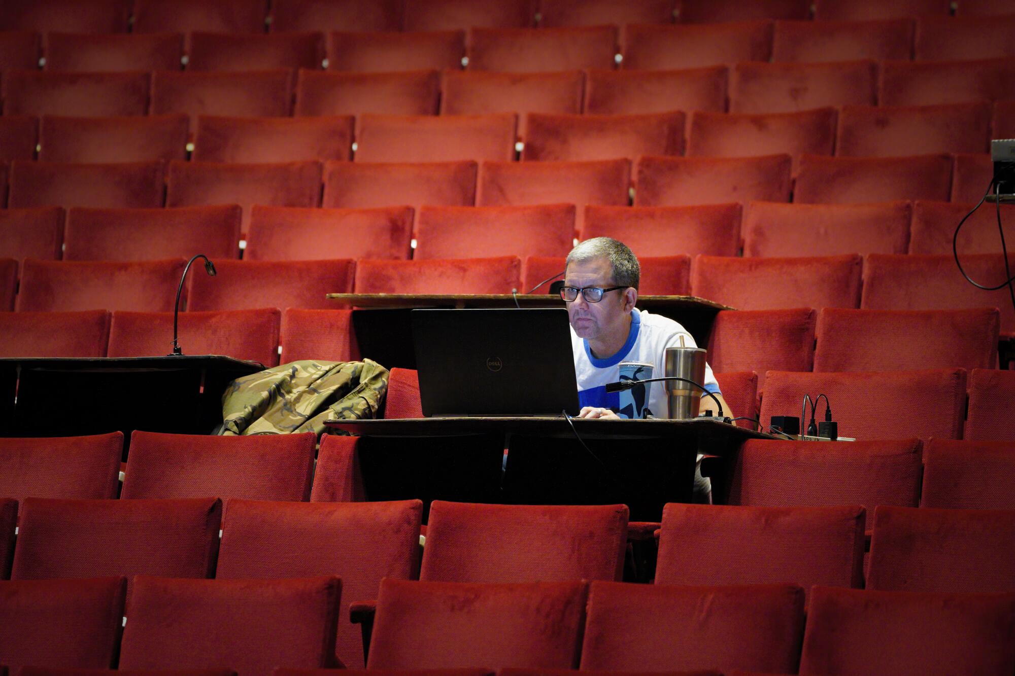 Technical Director, Tim Wallace works from his temporary desk set in the audience.