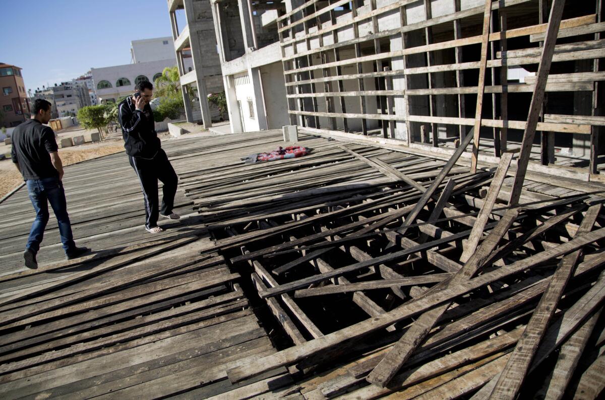 Palestinians inspect damage to a wooden stage built by members of the Fatah movement for a coming rally to mark the 10th anniversary of Yasser Arafat's death. The stage in Gaza City was hit by an explosion on Nov. 7.