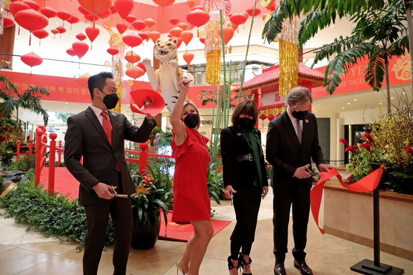 From left, Brian Chuan, senior director; Molly Unger, general manager; Debra Gunn Downing, executive director of marketing; and Anton Segerstrom participate in a ribbon-cutting on Thursday for South Coast Plaza's Lunar New Year celebration for the Year of the Tiger.