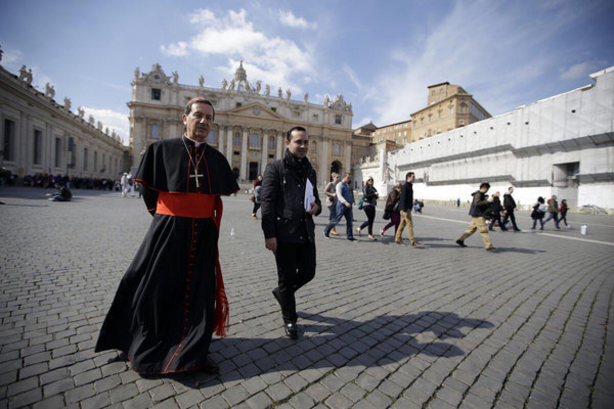 Colombian Cardinal Ruben Salazar Gomez, left, walks in St. Peter's Square after attending a cardinals meeting at the Vatican.