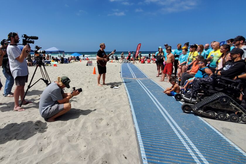 "Making Good" host Kirby Heyborne sings a song to participants in a Life Rolls On adaptive surf clinic.
