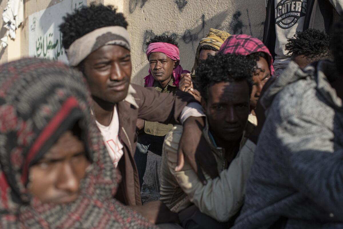 Abdul Karim Trat, a migrant from Ethiopia, sits by the roadside in the Yemeni city of Ataq.