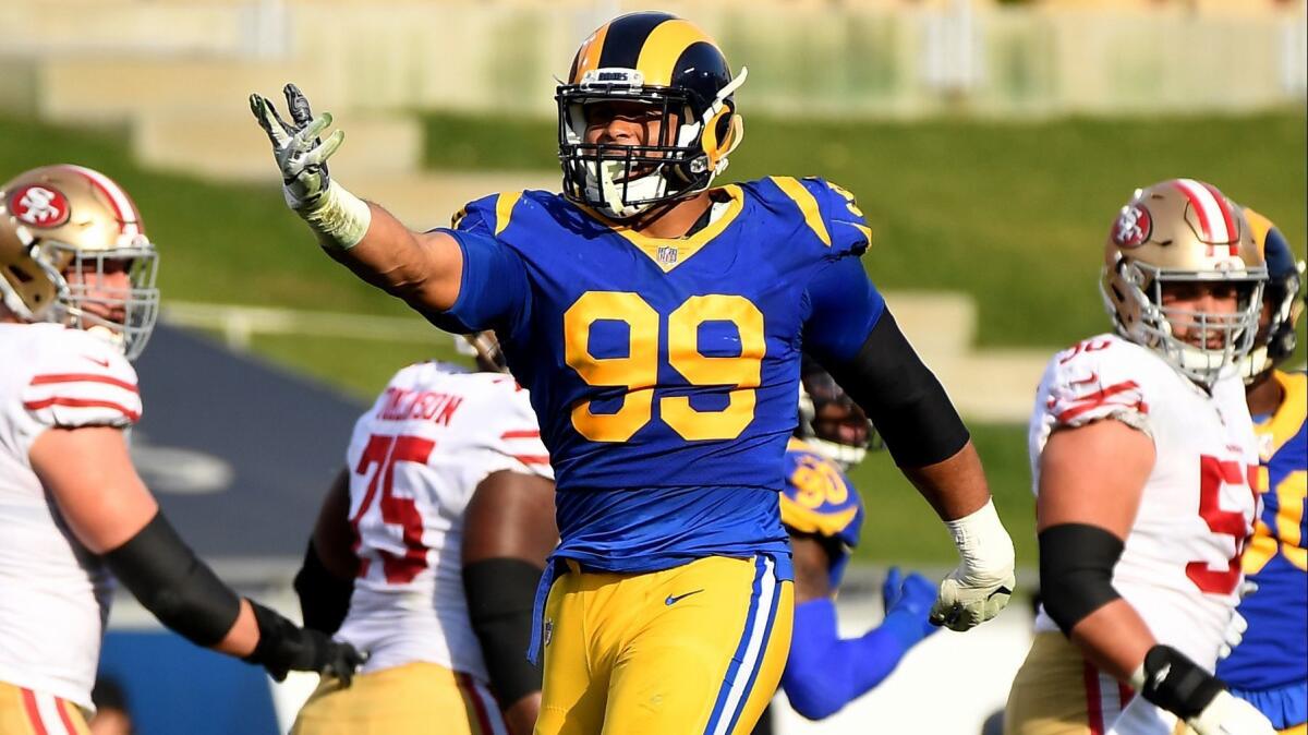 Rams Aaron Donald celebrates his sack of 49ers quarterback Nick Mullens in the first quarter at the Coliseum.