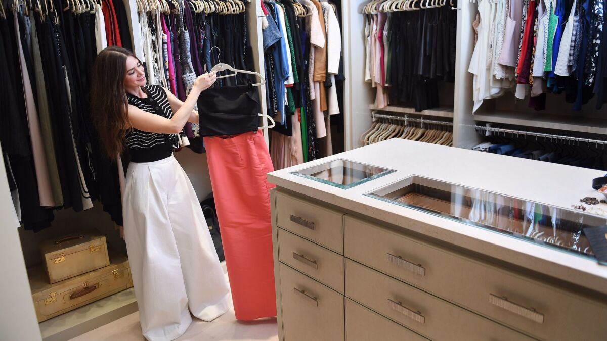 Rochelle Gores Fredston shows some of the designer pieces that stock her closet.