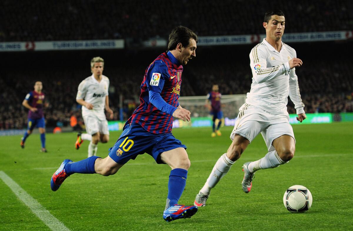 ARCHIVO - Lionel Messi (izquierda) del Barcelona disputa el balón con Cristiano Ronaldo del Real Madrid