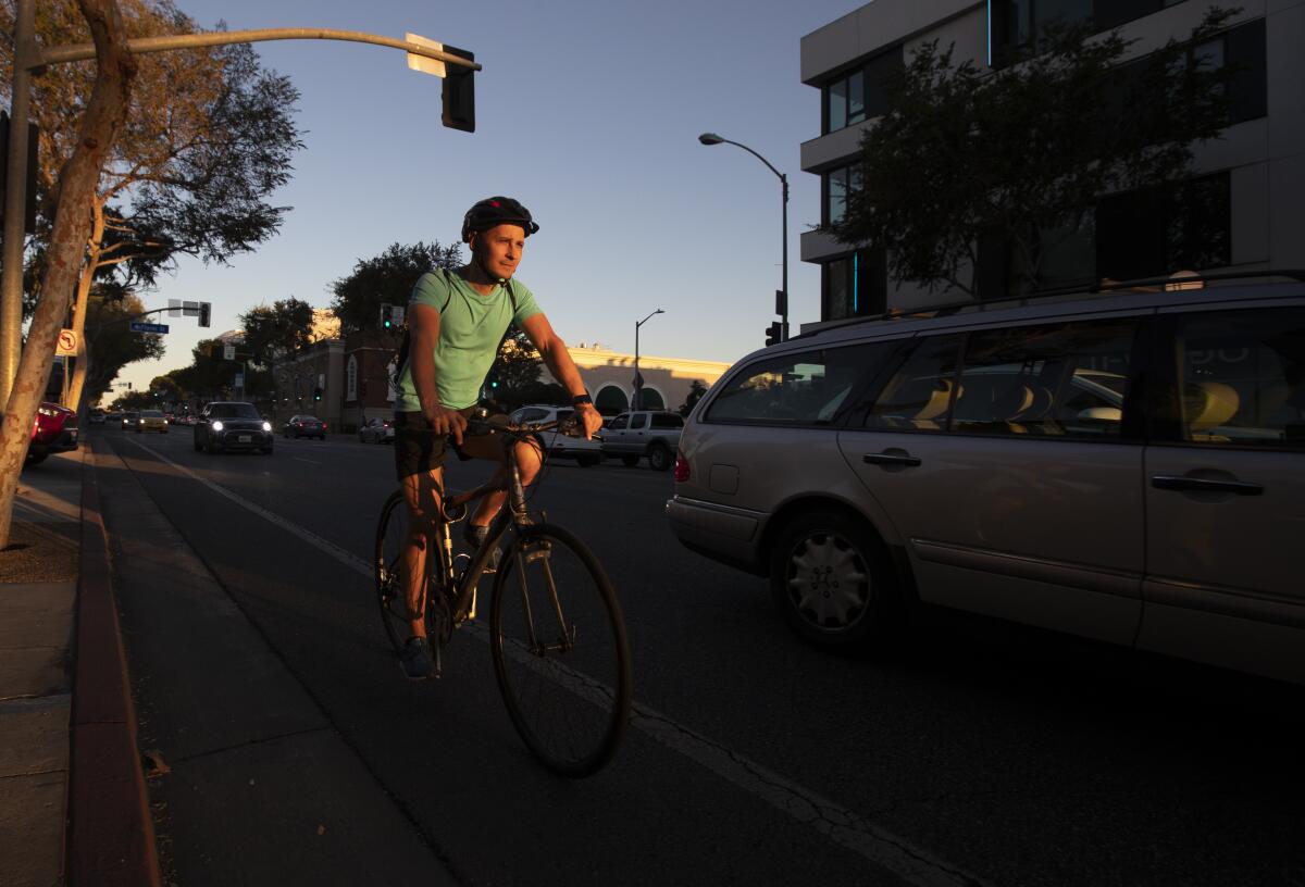 A person rides in the bike lane along Santa Monica Blvd. at sunset