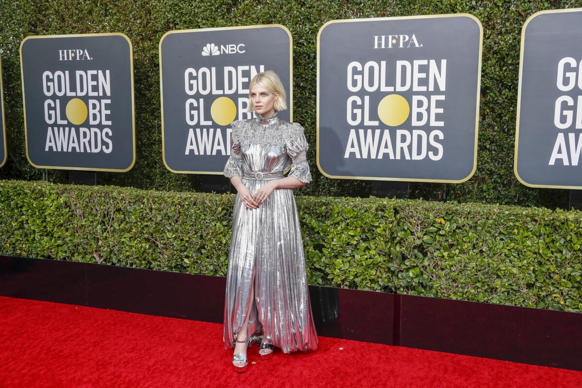 On the fence: Lucy Boynton in a silver Louis Vuitton gown.