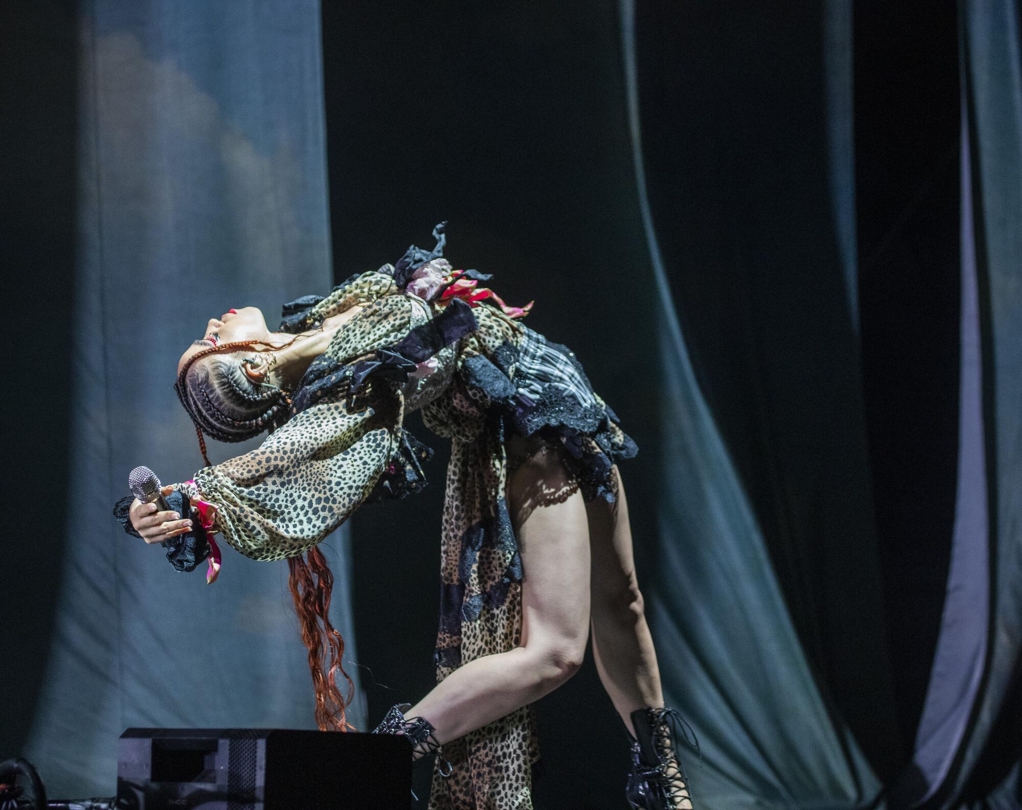 A vocalist poses onstage successful an elaborate outfit.