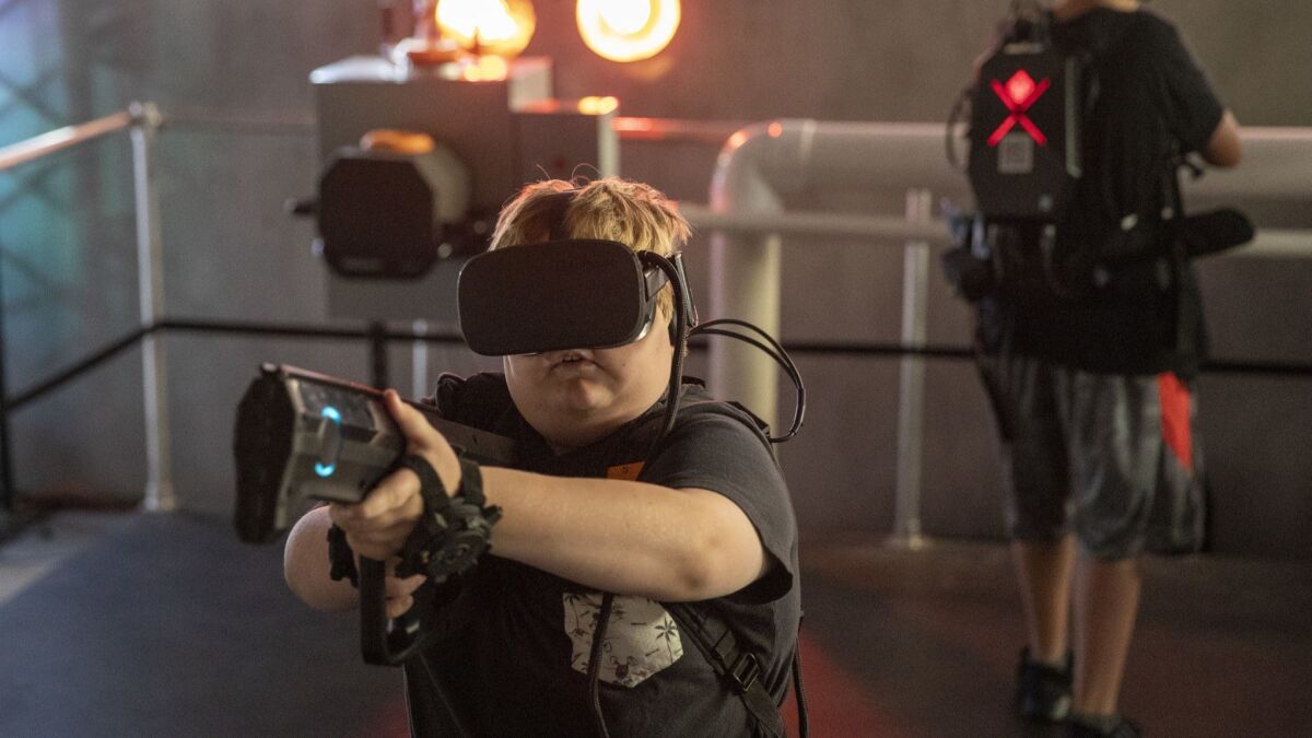 Jack Dion, left, 10, and Kyle Mendoza, 14, of Santa Ana play at the location-based virtual reality start-up called "Terminator Salvation: Fight for the Future" in the former Red Robin building at the Irvine Spectrum Center.