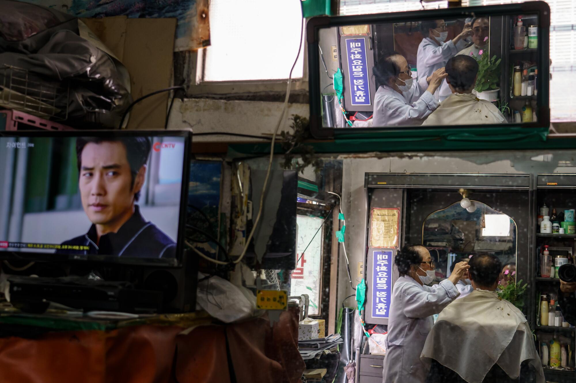 South Korean barber Lee Duk-hoon trims a customer's hair in Seoul