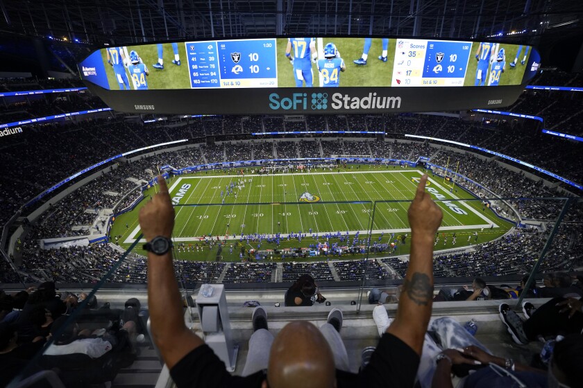 A fan cheers from the upper deck at SoFi Stadium.
