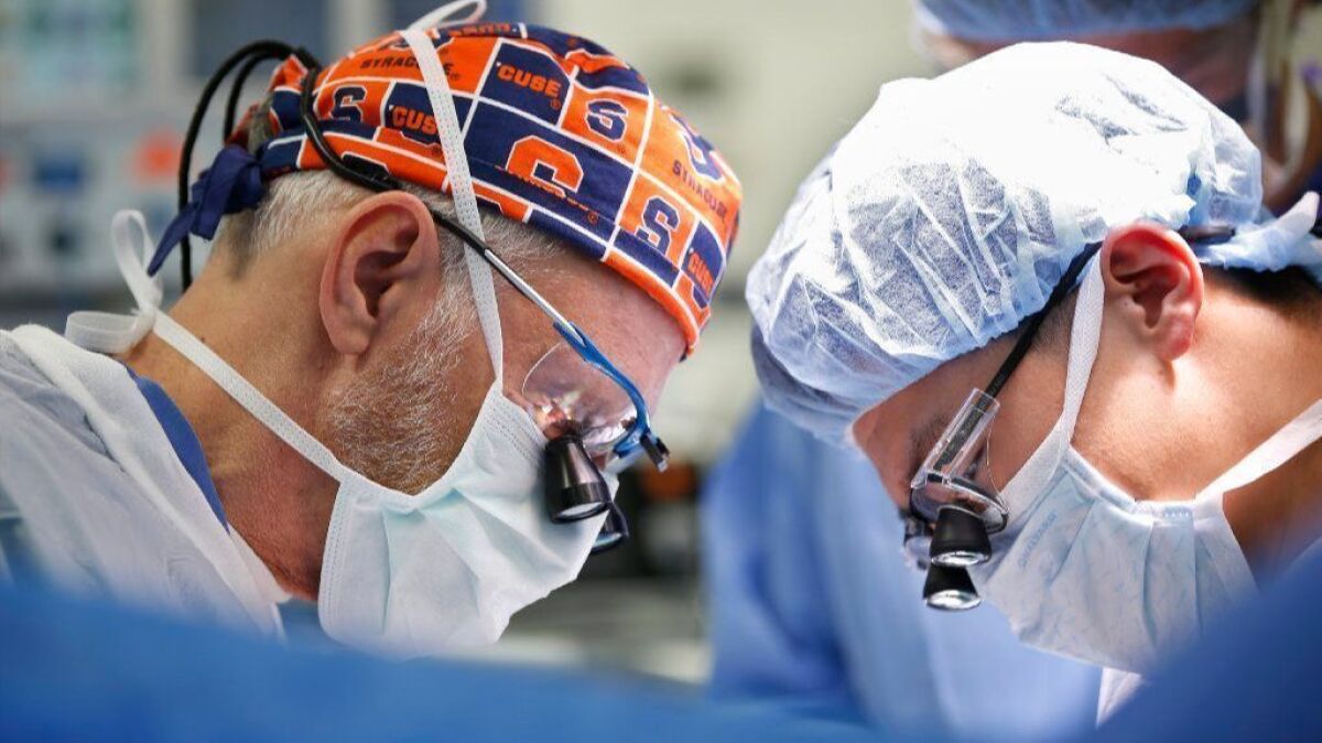 Dr. Andrew Lowy, left, removes a pancreatic tumor at the Jacobs Medical Center at UC San Diego Health. At right is Shanglei Liu, MD, resident physician.