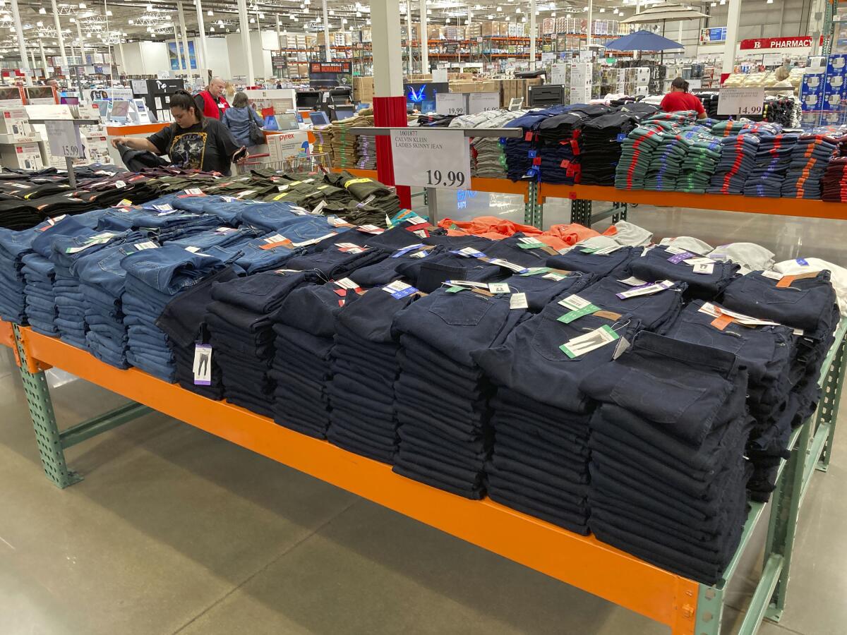 Shoppers peruse jeans on display in a Costco store