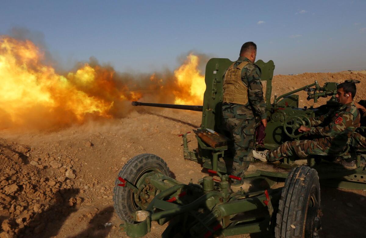 Iraqi Kurdish Peshmerga fighters fire an anti-tank cannon on the front line near Hasan Sham village, east of the city of Mosul, Saturday during an operation aimed at retaking areas from Islamic State.