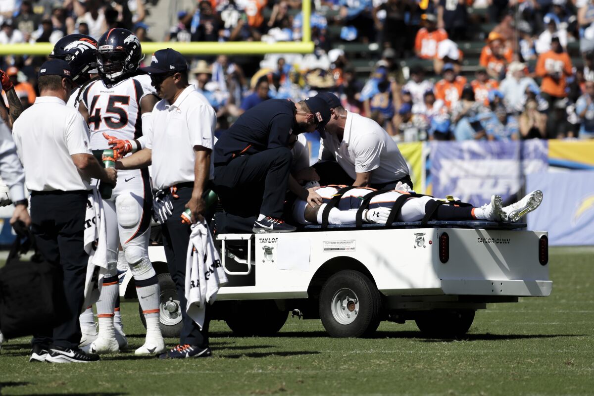 FILE - In this Sunday, Oct. 6, 2019 file photo, Denver Broncos cornerback DeVante Bausby is taken off the field after being hurt during the first half of an NFL football game against the Los Angeles Chargers, in Carson, Calif. Broncos cornerback De'Vante Bausby says he was paralyzed for 30 minutes Sunday after he wrenched his neck colliding with linebacker Alexander Johnson while making a tackle on Chargers running back Austin Ekeler. (AP Photo/Alex Gallardo, File)