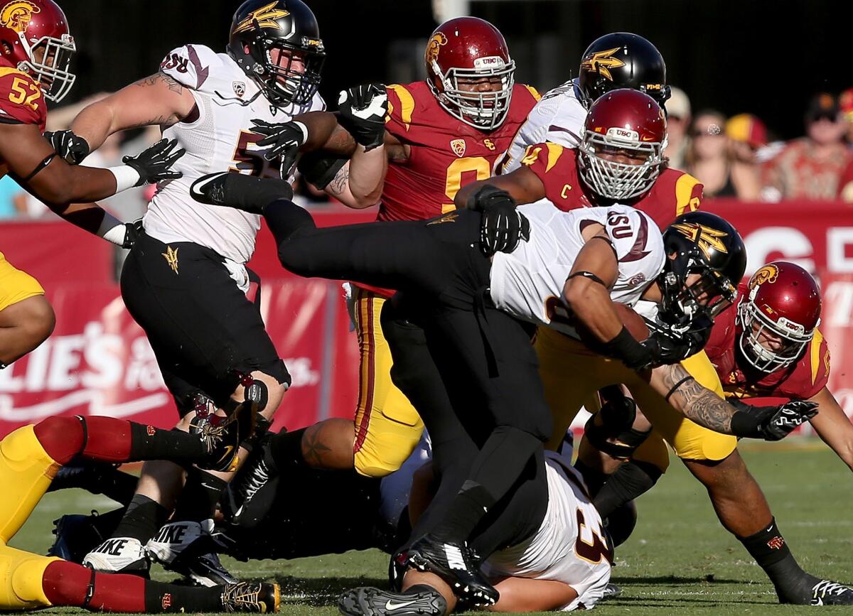 Trojans defensive end Leonard Williams brings down Sun Devils running back D.J. Foster in the first quarter of their game.