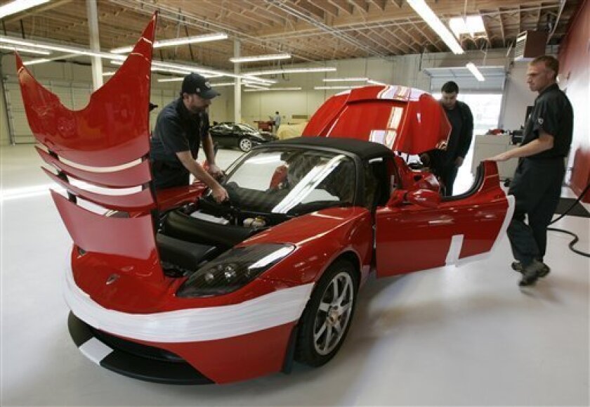 Tesla workers assembly a Tesla Roadster at their showroom in Menlo Park, Calif., Tuesday, Sept. 16, 2008. Tesla expects final approval of a deal with the city of San Jose, Calif., for a plant to build the Model S, an all-electric sedan. Tesla's cars run on a massive lithium-ion battery pack that can be recharged by plugging an adapter cord into a wall socket. (AP Photo/Paul Sakuma)