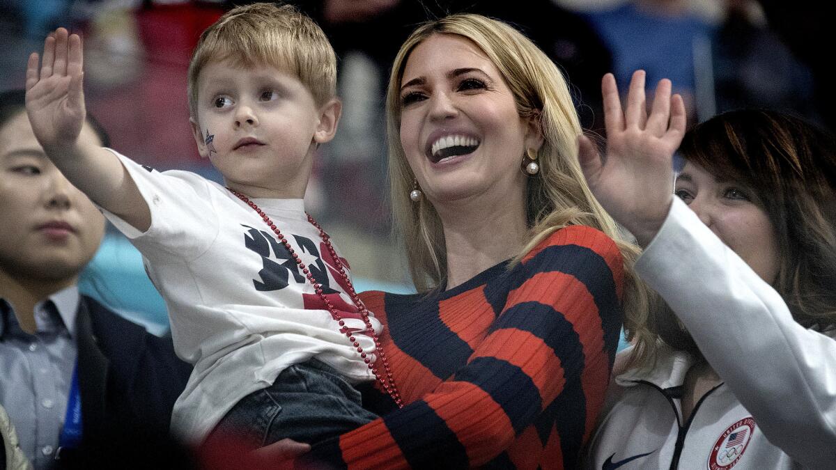 Ivanka Trump holds Luke Shuster as he waves to his father, John Shuster, after the U.S. defeated Sweden for the gold medal in men's curling on Saturday.