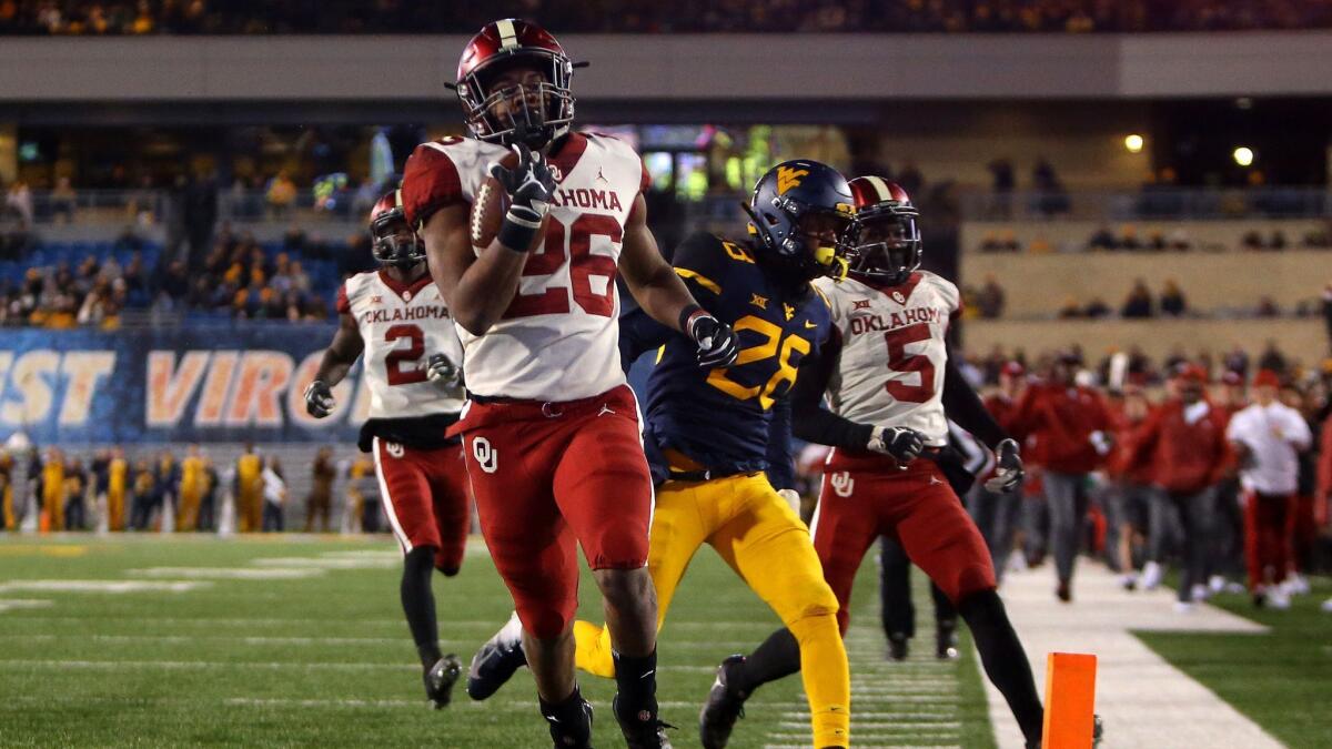 Kennedy Brooks (26) of the Oklahoma Sooners rushes for a 68-yard touchdown against the West Virginia Mountaineers.