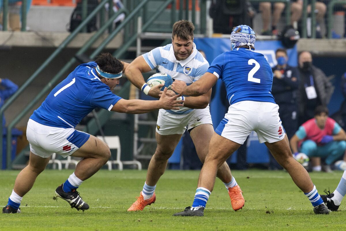 FILE - From left, Italy's Ivan Nemer, Argentina's Facundo Isa, and Italy's Gianmarco Lucchesi fight for the ball during a rugby union international match between Italy and Argentina at the Monigo stadium in Treviso, Italy, on Nov. 13, 2021. Benetton and Italy prop Ivan Nemer was suspended until the end of the season on Friday Jan. 27, 2023 after giving a rotten banana to a Black teammate. (AP Photo/Paolo Giovannini, File)