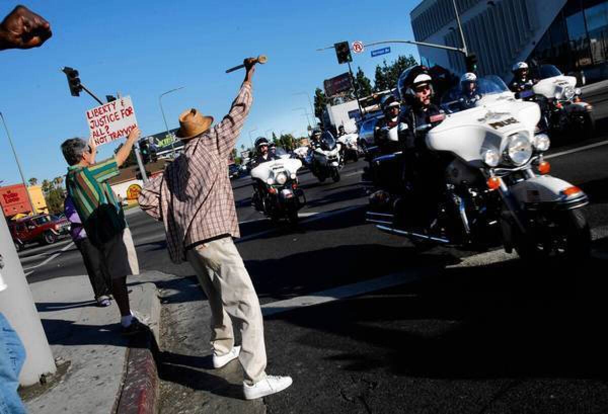 Protesters yell at LAPD motorcycle officers in Leimert Park on Tuesday. Police have vowed a stepped-up response to unrest.