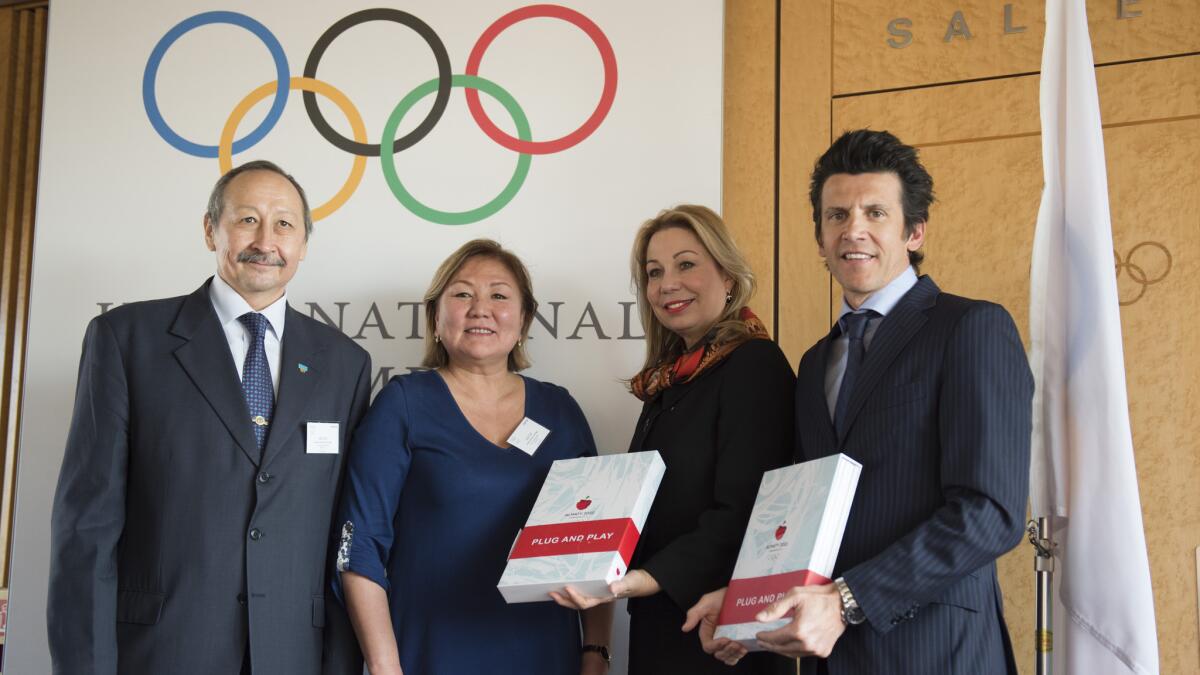 Members of the Almaty Olympic Winter Games committee, from left, Timur Dossymbetov and Zauresh Amanzhilova stand next to IOC members Jacqueline Barrett and Christophe Dubi at the IOC's headquarters in Lausanne, Switzerland on Tuesday.