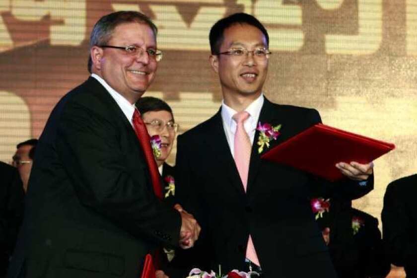 Gerry Lopez, chief executive of AMC Entertainment Holdings, left, shakes hands with Zhang Lin, vice president of Wanda, during a signing ceremony as Dalian Wanda Group acquires AMC Entertainment in May 2012.