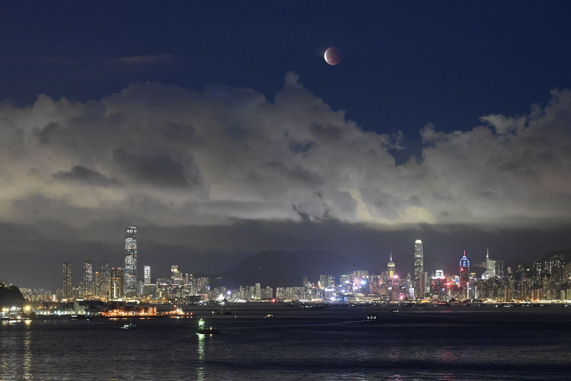 The moon rises over the Victoria Harbor
