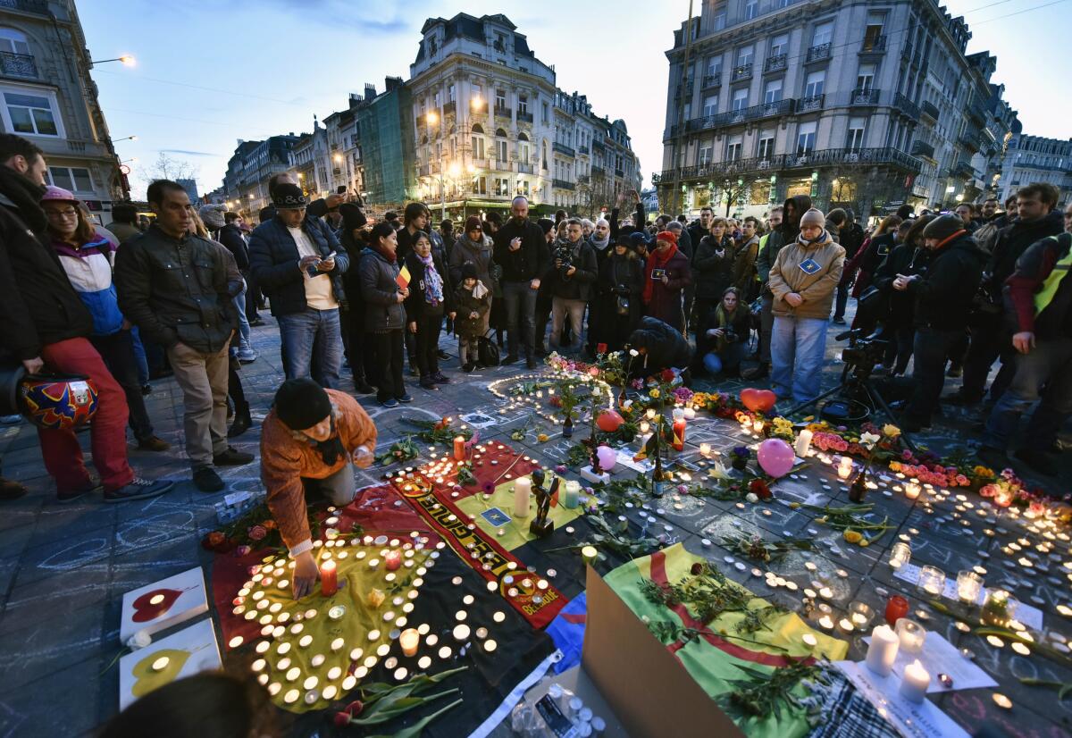 Mourners add candles, flowers and other objects to a growing street memorial outside the Brussels stock exchange.