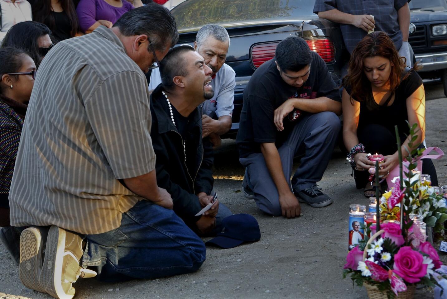 Rudy Coronado, center, grieves at a vigil for his young daughters, who were allegedly killed by their mother.