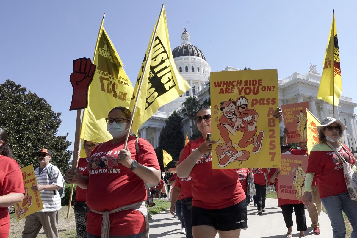 Fast-food workers and their supporters march past the state Capitol in Sacramento.