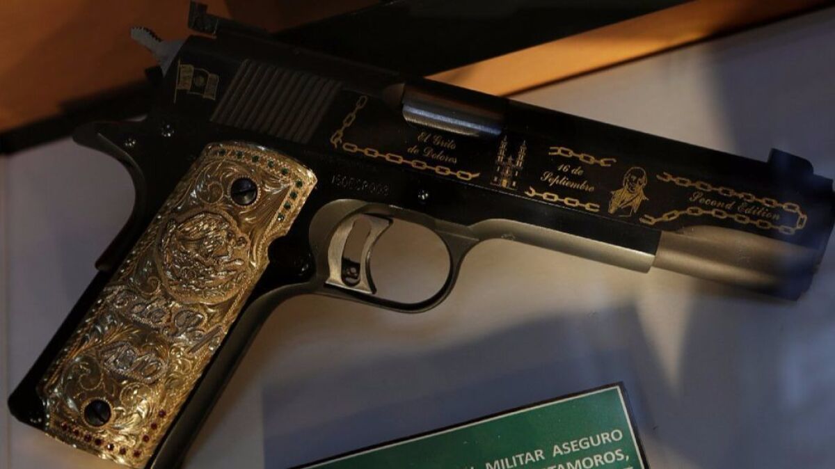 A gun decorated with gold belonging to Mexican drug lord of the Gulf Cartel, Osiel Cardenas Guillen, is displayed in the Drugs Museum at the headquarters of the Ministry of Defense in Mexico City.