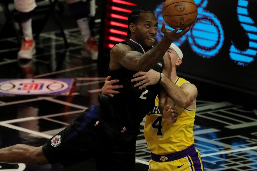LOS ANGELES, CA - MAY 6, 2021: LA Clippers forward Kawhi Leonard (2) is fouled by Los Angeles Lakers guard Alex Caruso (4) as he drives to the basket in the second half at Staples Center on May 6, 2021 in Los Angeles, California.(Gina Ferazzi / Los Angeles Times)