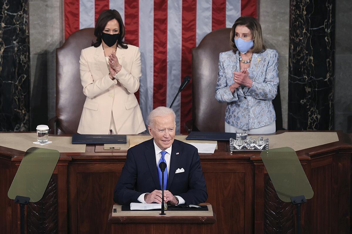 President Biden speaks in the House chamber. Behind him are Vice President Kamala Harris, left, and Speaker Nancy Pelosi.