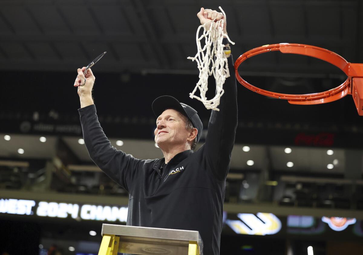 Long Beach State coach Dan Monson celebrates after cutting down the net following a win over UC Davis.