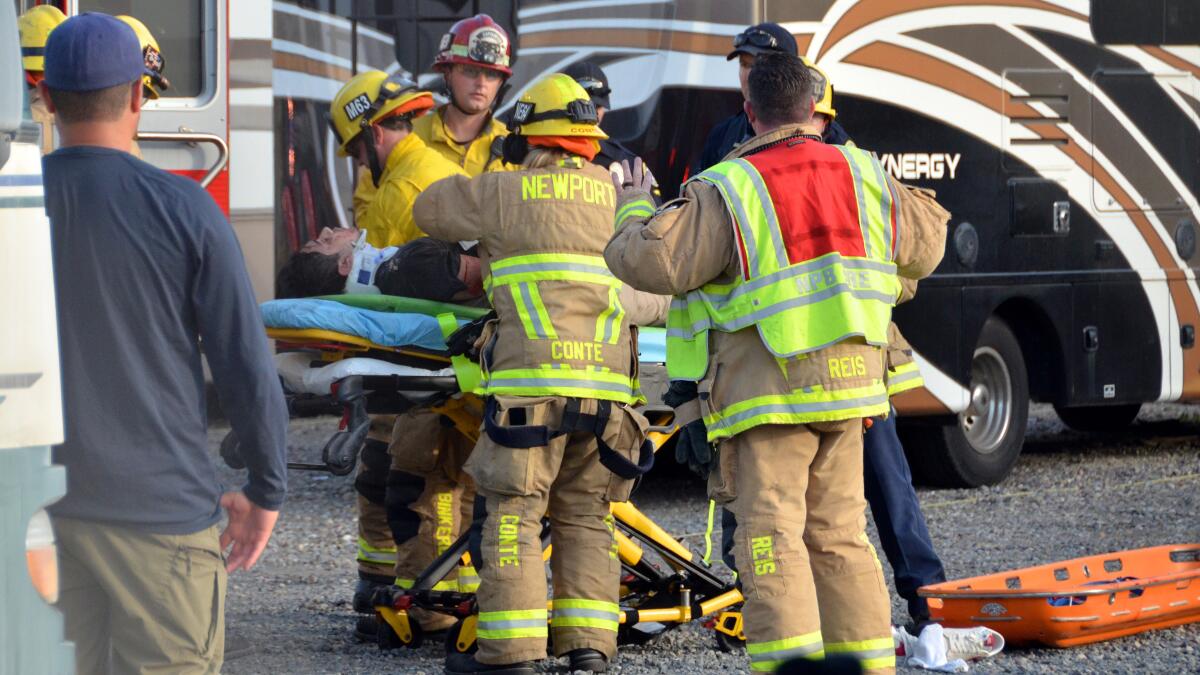 The driver of the car that careened off Pacific Coast Highway is loaded into an ambulance by NBFD emergency responders.
