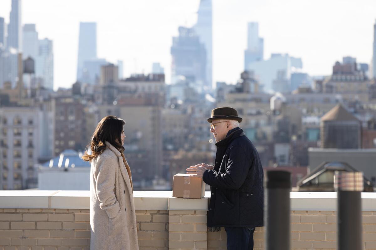 A young woman and older man find a box on a building rooftop in "Only Murders in the Building."
