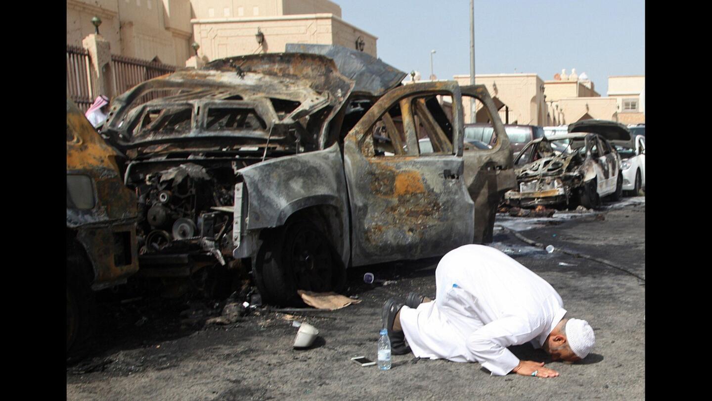 The cousin of a victim prays at the site of a suicide bombing outside a Shiite Muslim mosque in the Saudi city of Dammam on May 29.