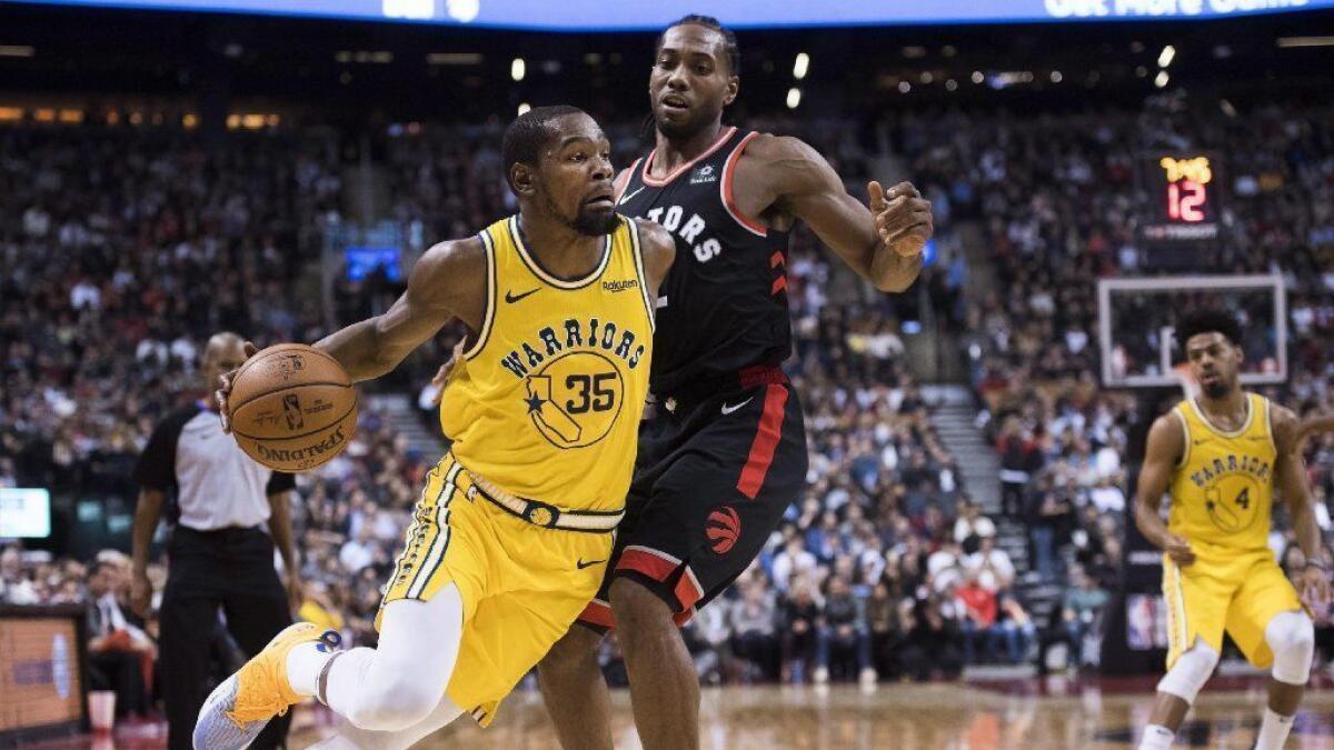 Then-Golden State Warriors forward Kevin Durant (35) drives around Toronto Raptors forward Kawhi Leonard (2) during the second half of an NBA basketball game Nov. 29 in Toronto.
